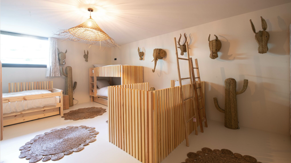 Décoration intérieure d'une chambre d'enfants axée sur les matières naturelles : lits et décoration murales en bois, suspensions en rotin