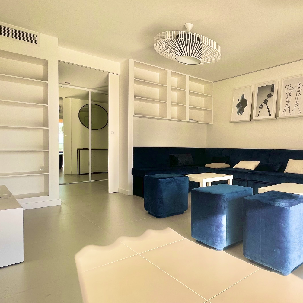 Agencement d'un salon lumineux décoré avec un mobilier en coloris bleu pour un appartement de vacances