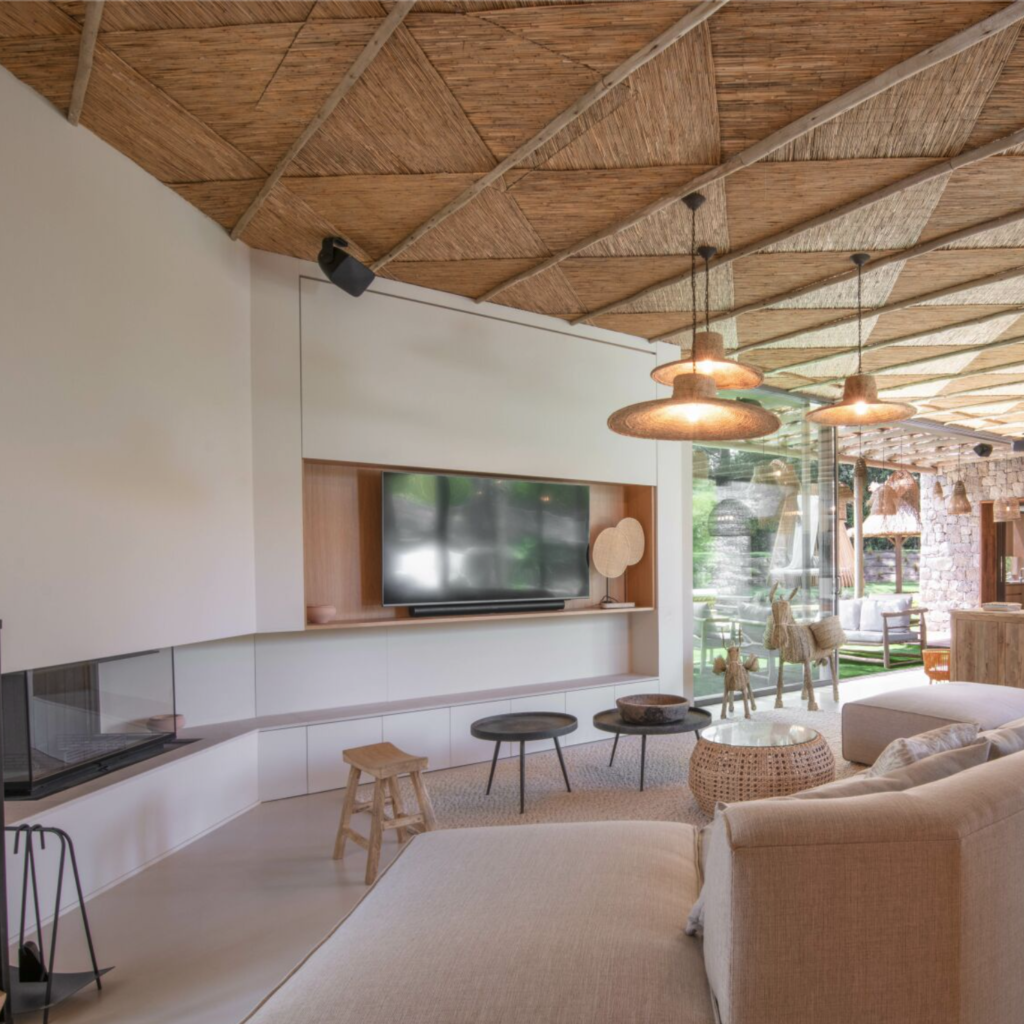 Aménagement intérieur de la Villa Balagan. Salon spacieux avec une décoration épurée : plafond en eucalyptus, mobilier bois et rotin, teintes naturelles