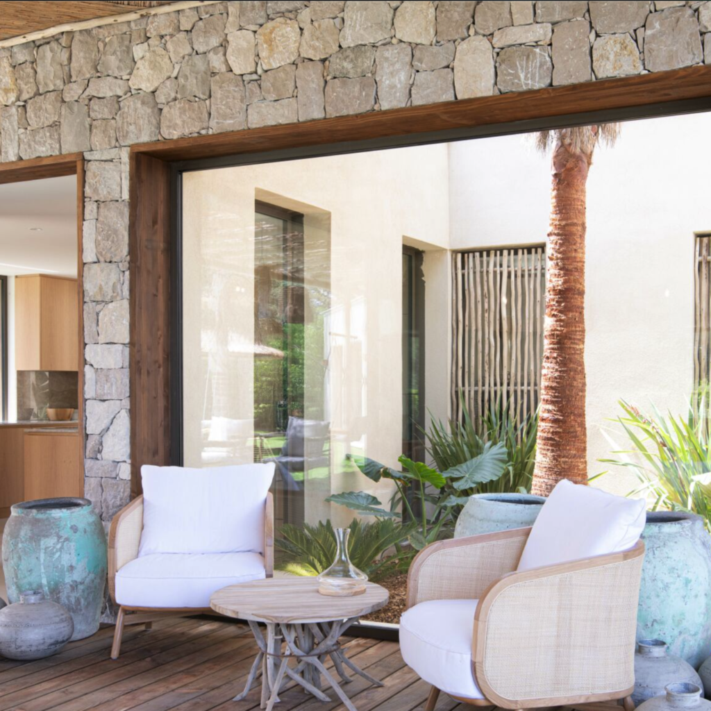 Villa Balagan : aménagement d'un coin salon style nature avec une baie vitrée, pierre naturelle murale