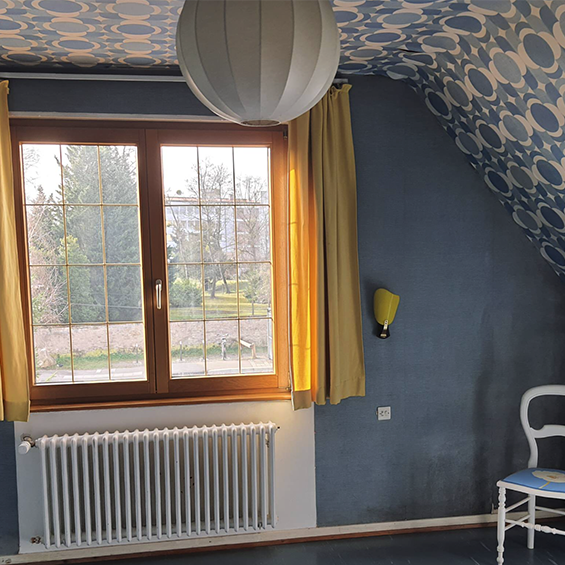 Aperçu avant rénovation : décoration style années 60/70 avec papier-peint à grands motifs au plafond